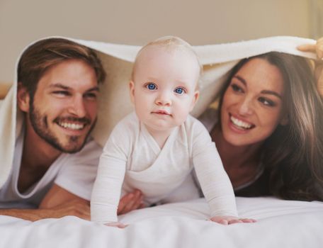 One happy family. a young couple and their baby daughter in the bedroom.