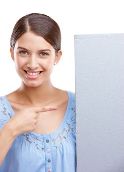 Portrait, pointing and poster with a woman in studio isolated on a white background holding a blank sign for branding. Logo, marketing and brand with a female showing mockup space for advertising