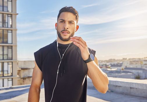Nothing makes you want to move like music does. a man wearing earphones while standing outside in exercise clothes.
