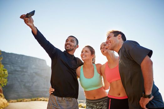 The world deserves to see how great we look. a fitness group taking a selfie while out for a run together.