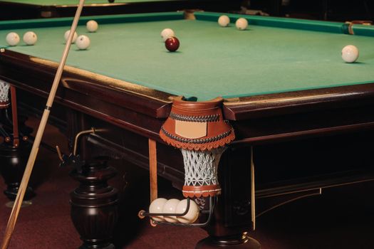 A pool table with balls that have already been played in the pool club.Playing billiards