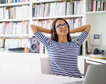 Working from the comfort of home. a woman looking relaxed in her home office.