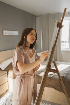 Pretty talented woman painter painting on easel making colorful sketches creating wonderful art. Beautiful female artist painting with pastel. Creativity and imagination concept