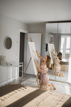 Pretty talented woman painter painting on easel making colorful sketches creating wonderful art. Beautiful female artist painting with pastel. Creativity and imagination concept