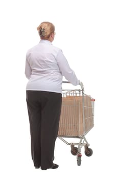 Rear view of casual woman with empty shopping cart on white background