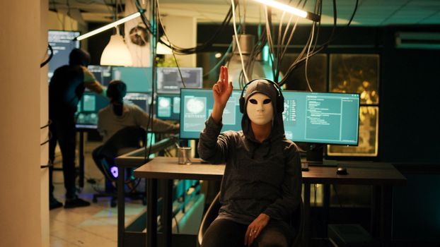 Anonymous hacker with mask using hologram to hack computer server