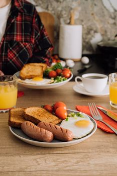 Cooked English breakfast with coffee and orange juice in the kitchen at home