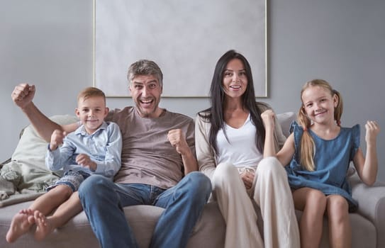 Family sitting in living room smiling at home