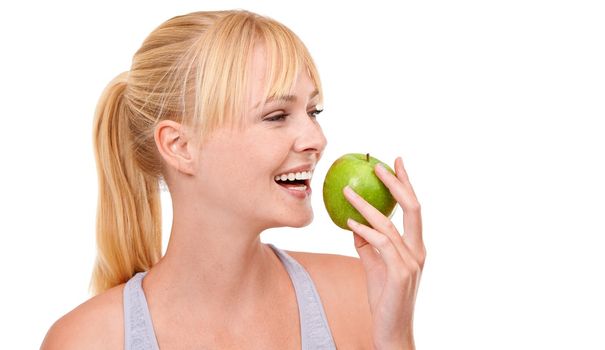 Ill always take the healthy option. An attractive young woman eating an apple isolated on white.