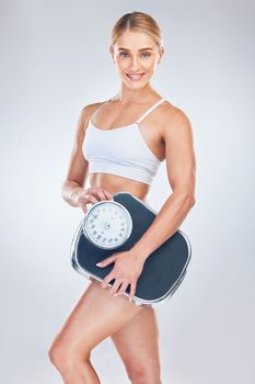 Portrait, young woman and scale for weight loss, wellness and fitness with studio background. Health nutrition, healthy female or trainer happy, for results after weighing and body care for wellness