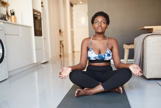 Fitness will change your mind, attitude and mood. a young woman meditating at home.