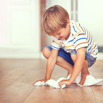 Ill clean this before mom sees...a little boy wiping the floor with tissues.