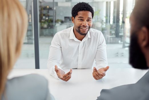 Black businessman, meeting or job interview in office boardroom with human resources, recruitment or corporate hiring managers. Talking worker, employee or hr candidate with happy smile or motivation