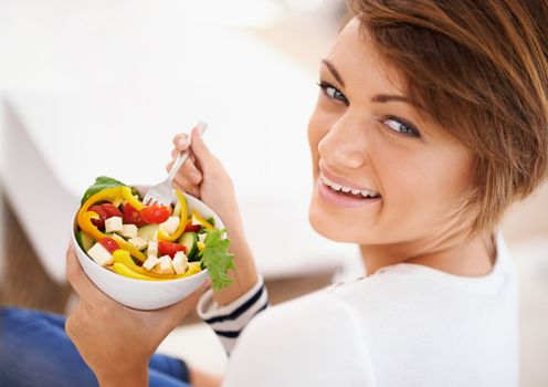Healthy eating is her best beauty treatment. an attractive young woman eating a salad.
