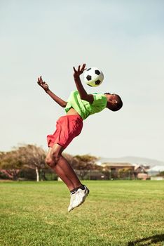 Showcasing great skill and agility. a young boy playing soccer on a sports field.