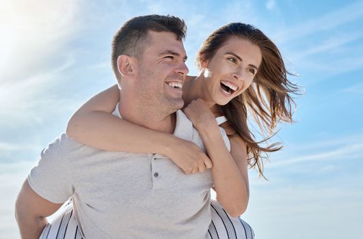 Love, beach and piggy back couple smile with blue sky on romantic summer holiday at ocean. Romance, man and woman have fun at sea for honeymoon, vacation time for happy couple together in Australia.