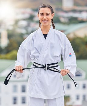 Karate, ready and portrait of a woman training on a rooftop for professional event, competition and fight. Black belt, fitness and taekwondo girl with a smile for sports, body power and martial arts