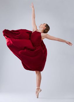 Ballet, dance and woman training for performance, wellness and hobby on grey studio background. Ballerina, creative dancer and female young person practice, routine and artist dancing, talent or free