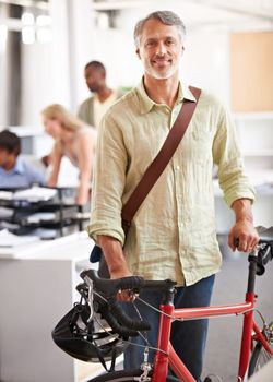 Eco-conscious business manager. An environmentally conscious business leader arriving at work with his bike.
