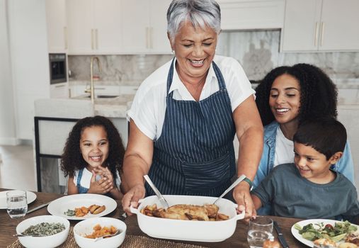 Grandmother, family home and kids at table for food, lunch or celebration with love, care and happiness. Black people, senior woman and children with dinner, party and happy for bonding in kitchen