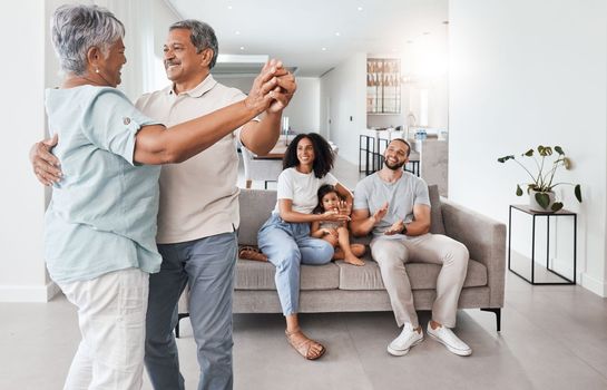 Senior couple, dancing and happy family with love, support and care together in home living room. Men, women and child or parents and grandparents in young for happy quality time and bonding in house