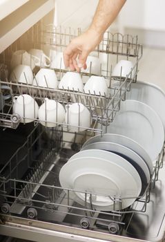 Dishwashing never has to be a chore again. a person loading a dishwasher at home.