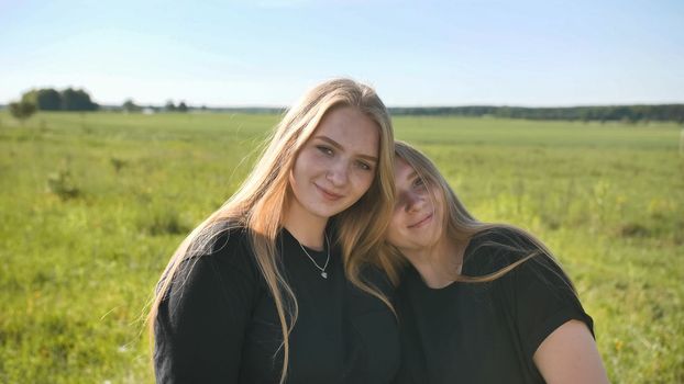 Portrait of two twin sisters in the field on a warm summer day