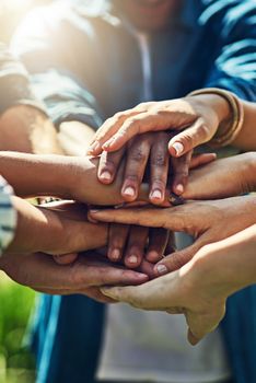 Good friends always stick together. Closeup shot of an unrecognizable group of people joining their hands in a huddle outdoors.