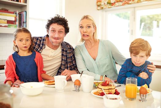 Goofing around at the breakfast table. Portrait of a family having fun while having breakfast together at home.