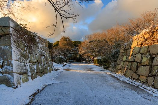 Stone walls of historic castle entrance in frosty morning sun