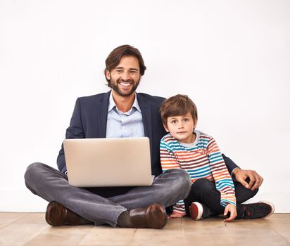 Hes the inspiration for my parenting blog. A father and son sitting on the floor with a laptop