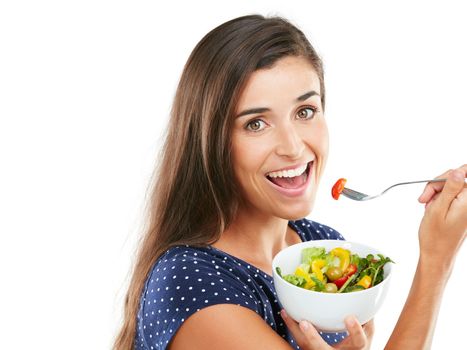 Eat clean, be happy. Studio portrait of an attractive young woman eating a healthy salad against a white background.