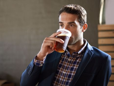 Nothing beats the refreshment of an ice cold beer. a handsome young man enjoying an ale at the bar.