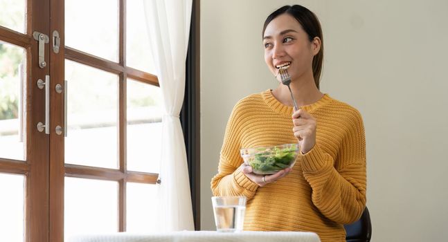Delighted woman eating food for health at home