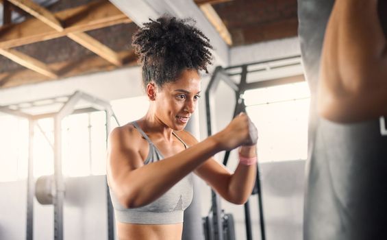 Fitness, black woman and boxing for training, exercise or healthy workout for strength or endurance at the gym. African American female boxer in sports activity hitting punching bag for self defense
