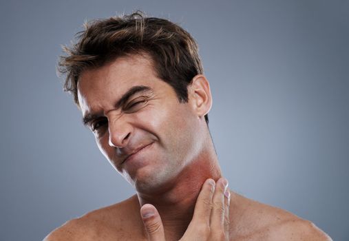 Razor burn is the worst. a young man grimacing from a bad rash on his neck.