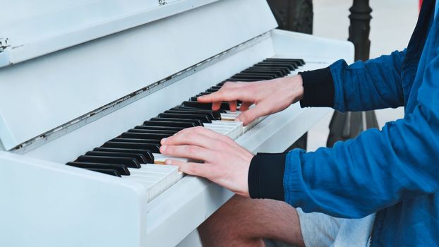 A street pianist plays the piano in the city.