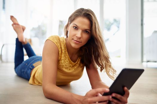 I have my series all lined up from the day. Full body portrait of an attractive young woman sitting and using a tablet in the living room during the day.