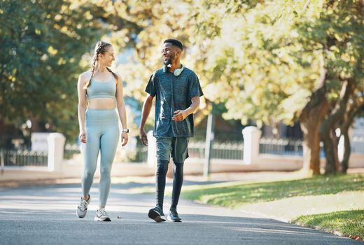 Workout, fitness and couple walk in nature together for wellness, bond and health in summer. Exercise and healthy lifestyle of people in interracial relationship walking in New York park.