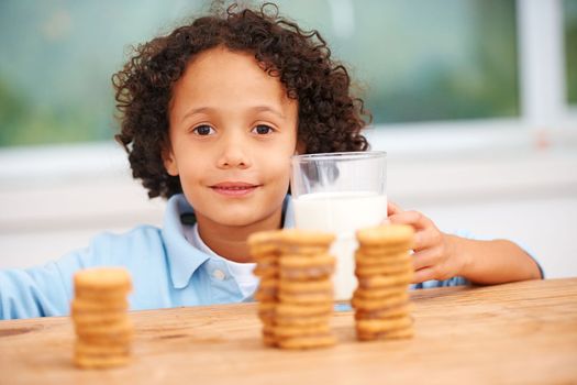 Mmm, so many cookies just for me. A cute young boy grabbing a cookie from the cookie jar.