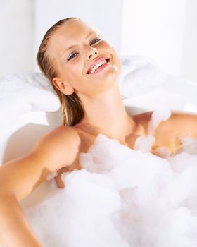 Restoring her energy with luxury. Happy young woman relaxed in a foamy bubble bath.