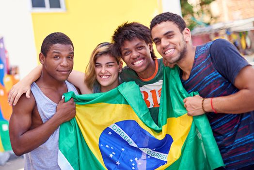 Proud of their nation. Portrait of a group of teenagers holding up the Brazilian flag.