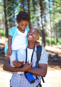Having a blast together. A happy young african father spending time with his daughter while outdoors in nature.