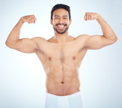 Fitness, biceps and portrait of a man flexing in a studio after an arm muscle training workout. Sports, health and strong Asian male bodybuilder after a strength exercise isolated by white background