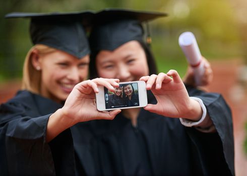 Keep calm and take a selfie. two college graduates taking a selfie.