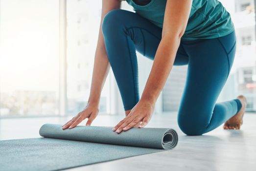 Yoga, studio and exercise mat with the hands of a black woman at the start of a zen workout. Fitness, training and roll with a female yogi indoor for mental health, balance or spiritual wellness