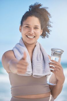 Thumbs up, water bottle and black woman in fitness, workout or training success, achievement and goal. Sports, runner girl on beach portrait with thank you, yes and like hand sign for healthy life