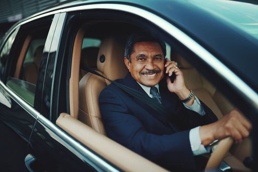 Success - the only way is forward. a mature businessman using his phone while traveling in a car.
