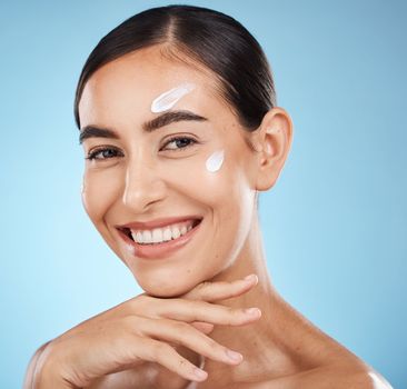 Skincare portrait, face cream and woman in studio isolated on a blue background. Cosmetics, dermatology and happy female model with lotion, creme or moisturizer for beauty, aesthetics and wellness.