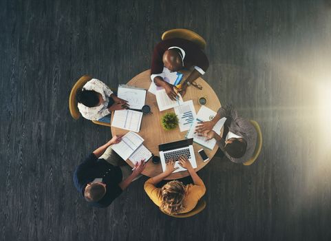 How the top workers get it done. High angle shot of a group of businesspeople having a meeting in a modern office.